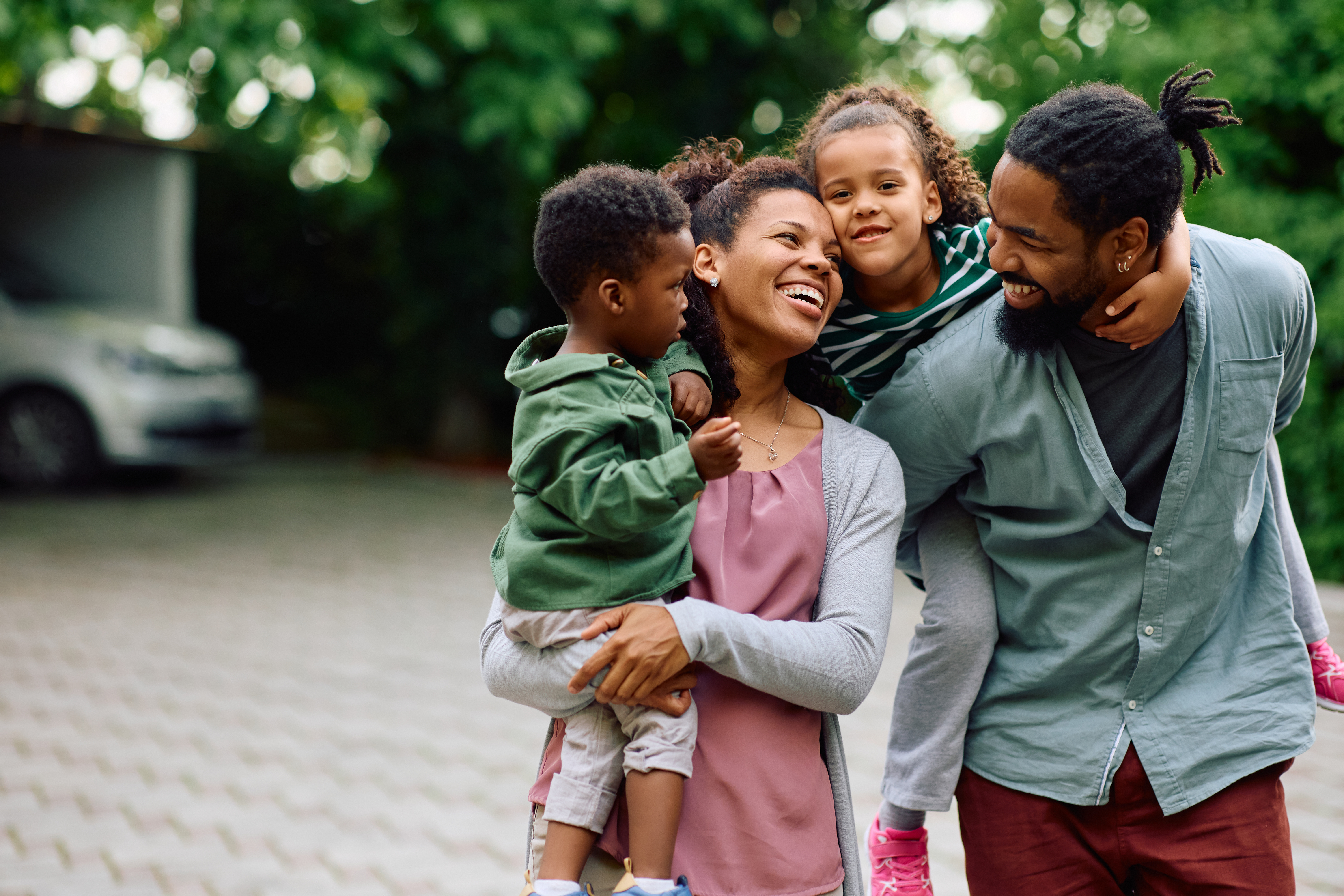 Mixed Race Family of 4, Mom, Dad, Child and Teenager smiling walking