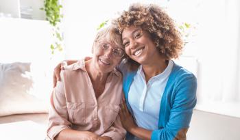 Younger caregiver with her arm around an older woman